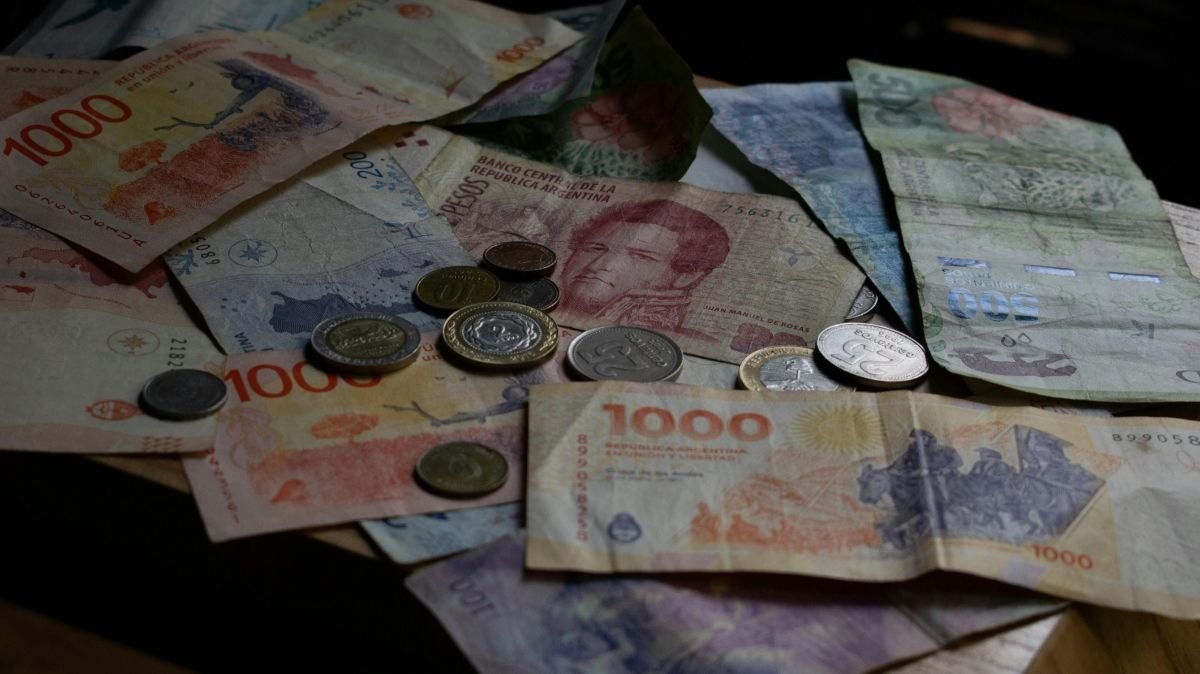 persona recibiendo pago con billetes argentinos por trabajo en feriado