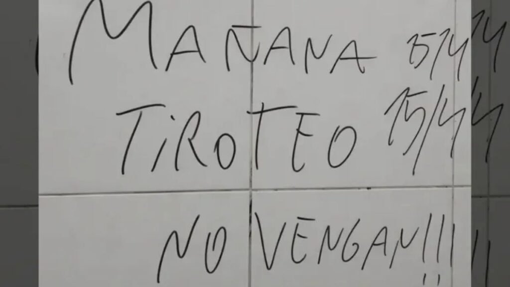 Mensaje con amenaza de tiroteo escrito en una pared dentro de una institución educativa.